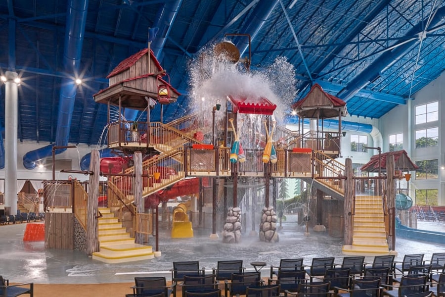 A wide shot of the  water treehouse as water splashes down from a bucket above the jungle gym